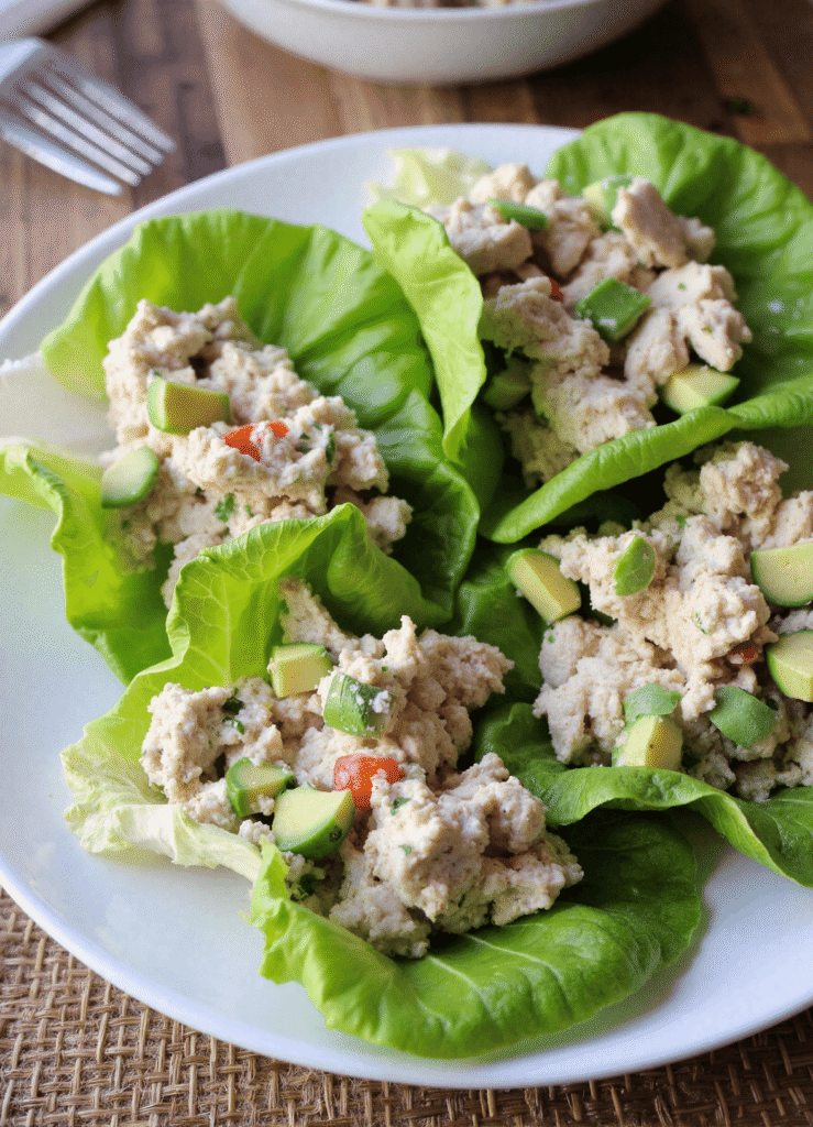 Healthy avocado chicken salad lettuce wraps filled with creamy avocado, lean chicken breast, and herbs served on crisp romaine lettuce leaves.