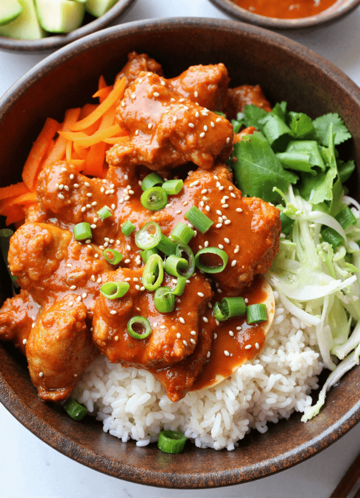 Spicy Bang Bang Chicken Bowl topped with sesame seeds, green onions, and fresh cilantro