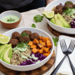 High-protein dinner bowl featuring barbecue meatballs, sweet potatoes, quinoa, fresh avocado, and herbs served in ceramic bowls.