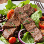 grilled steak salad with black beans, cherry tomatoes, red onion, and lettuce