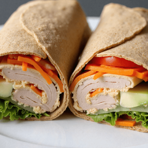 Grilled Greek chicken pita stuffed with juicy tomatoes, lettuce, red onions, cucumbers, and creamy tzatziki on a toasted flatbread.