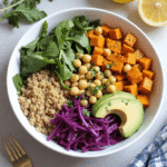 Open-face cottage cheese wraps filled with cucumbers, bell peppers, shredded carrots, and arugula, arranged on a white plate.