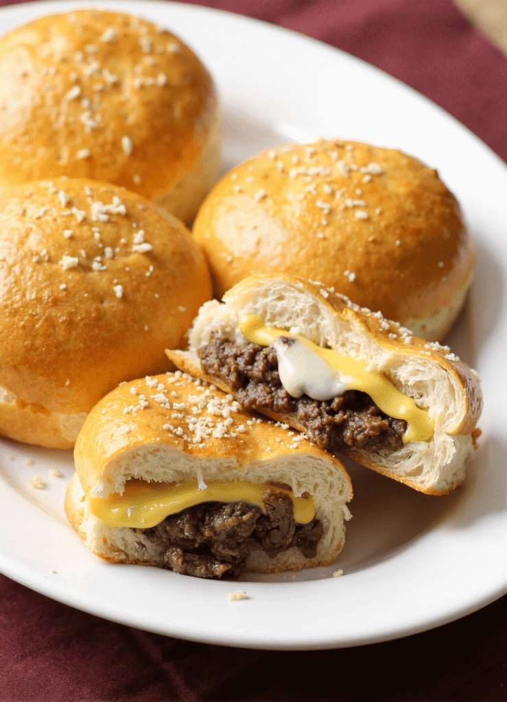 Stuffed cheeseburger bombs with melted cheese and seasoned beef inside golden baked dough, topped with Parmesan.