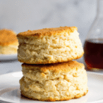 Golden brown breakfast protein biscuits stacked on a plate, showing fluffy layers and high-protein texture, perfect for busy mornings.