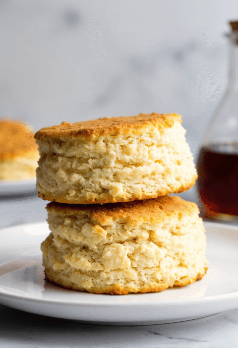 Golden brown breakfast protein biscuits stacked on a plate, showing fluffy layers and high-protein texture, perfect for busy mornings.